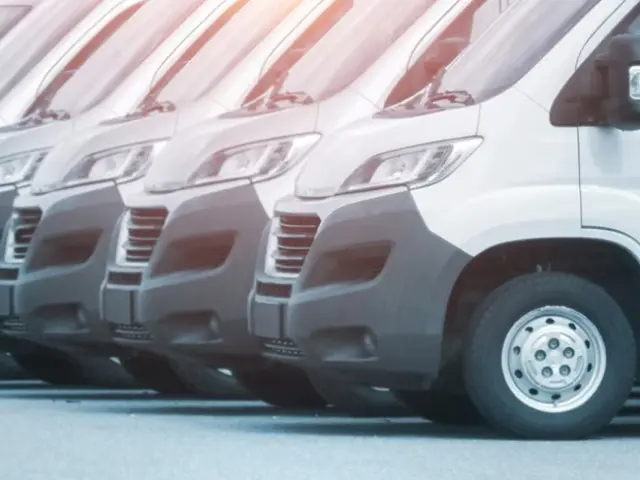 Une longue rangée de fourgonnettes de tourisme blanches.